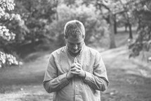 Man standing outside praying.