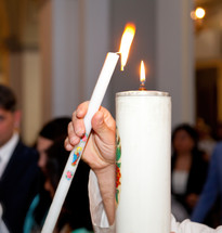 Priest lighting a candle during the sacrament of marriage 