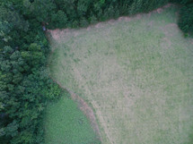 An aerial view of a field surrounded by trees.