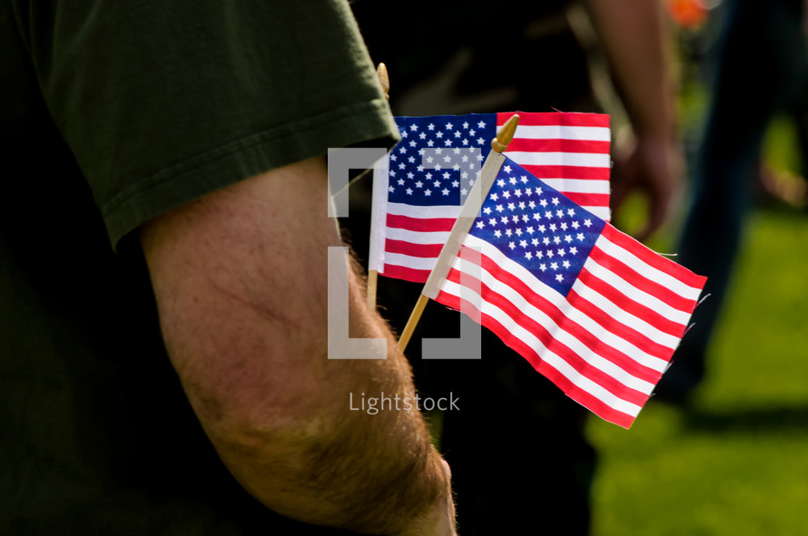 man holding small American flags - patriotism 