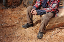 a hard working man taking a rest on fresh cut log