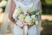 torso of a bride holding a bouquet 