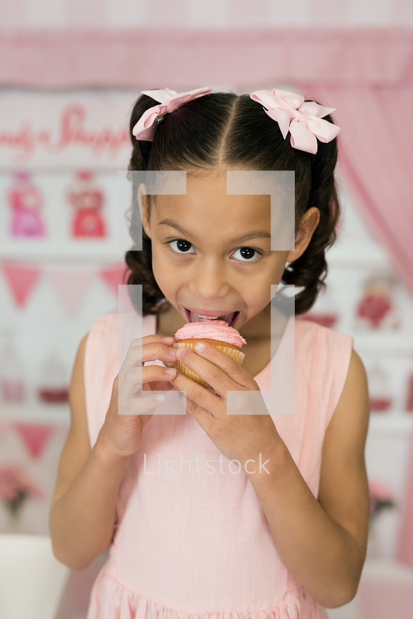 a girl eating a cupcake 