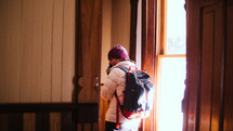 a woman bundled up standing in a ski lodge 