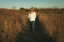 a teenager walking through a field 