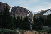 man backpacking and melting snow on a mountain 