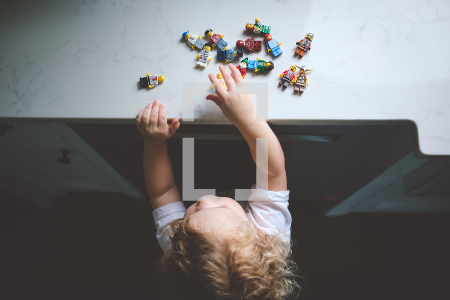 toddler playing with lego minifigures 