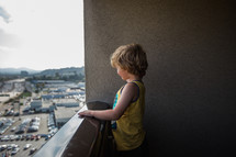 child looking over a balcony 