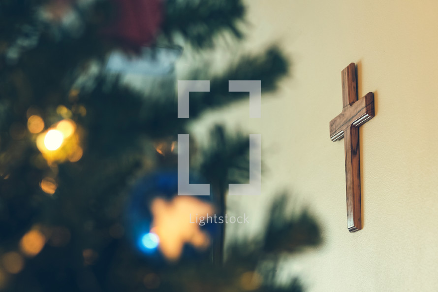 wooden cross on a wall and Christmas tree 