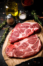 Raw pork steak on a stone board. On a black background. High quality photo