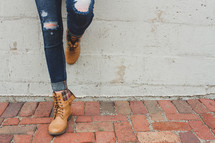 legs of a woman in ripped jeans and boots 