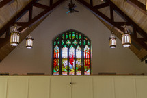 stained glass window and hanging lights in a church 