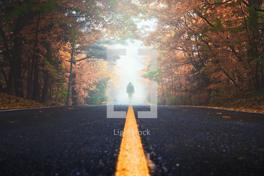 man standing in the middle of a road 
