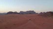 4x4 vehicle driving at sunset in the Wadi Rum desert in Jordan located in the middle east next to Israel.