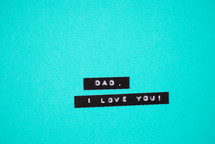 "Dad, I love you," on a blue background.