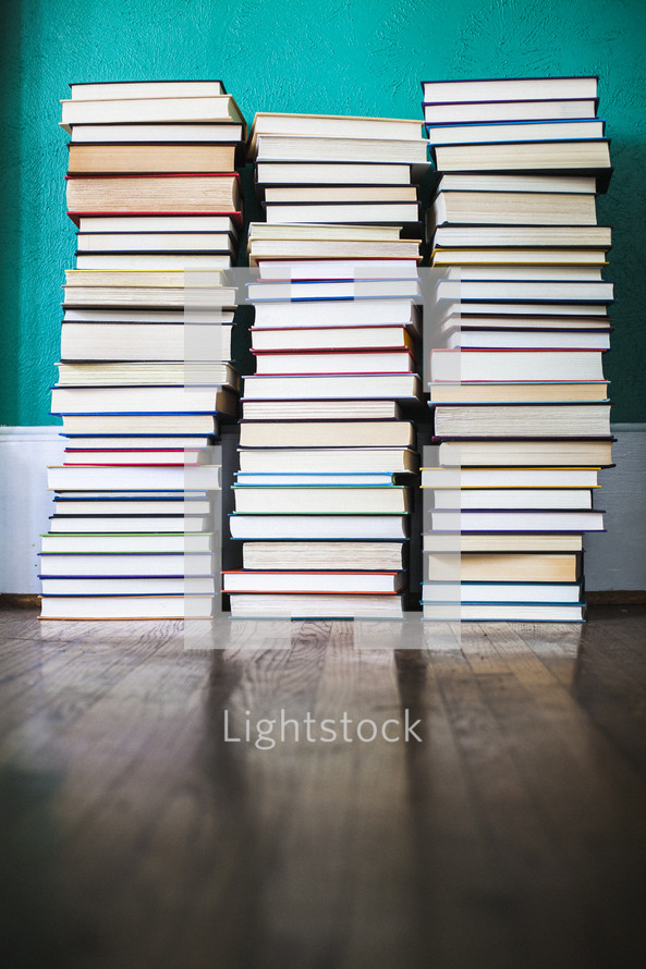 stacked books on a wood floor 