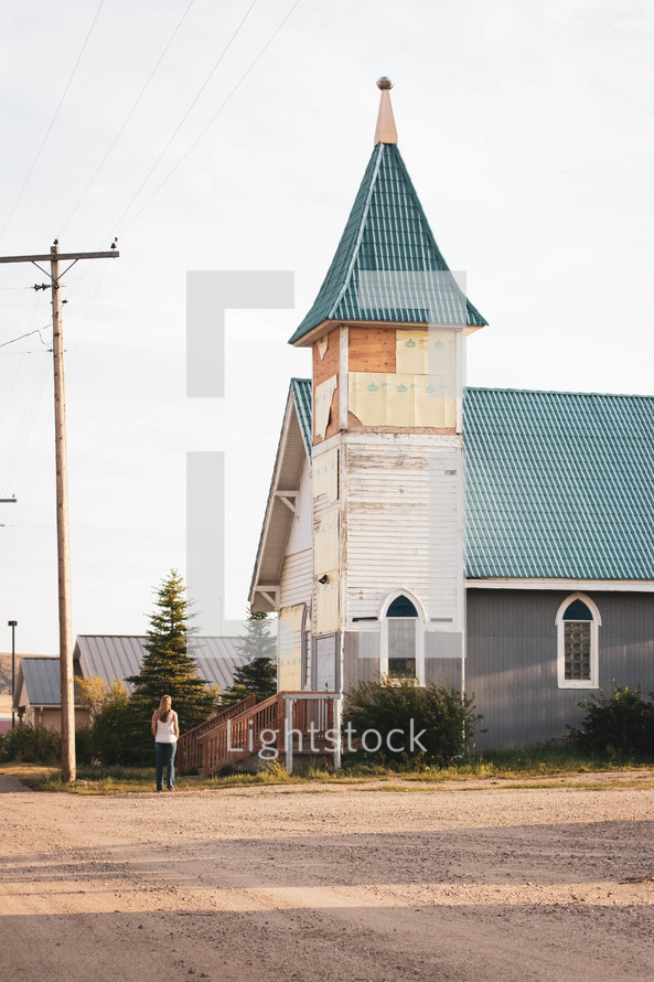 a female standing in front of a church 