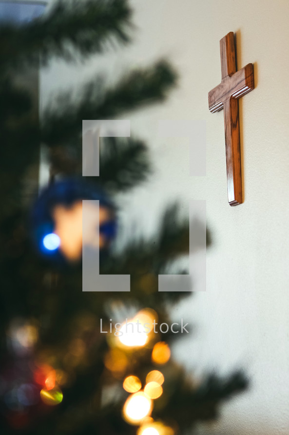wooden cross on a wall and a Christmas tree 
