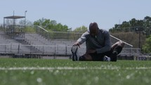 athlete stretching on a sports field 
