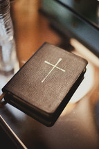 A closed bible with  a large cross on the cover