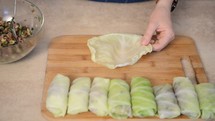 Female arms cooking of Russian national dish of cabbage rolls stuffed