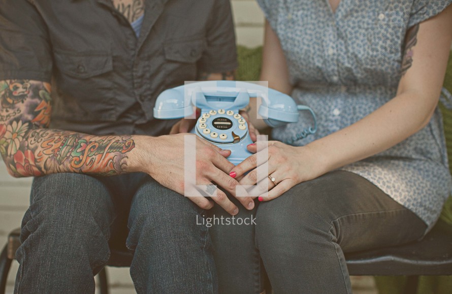 a couple sitting holding a phone in their laps