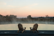 adirondack chairs on a dock at sunrise 