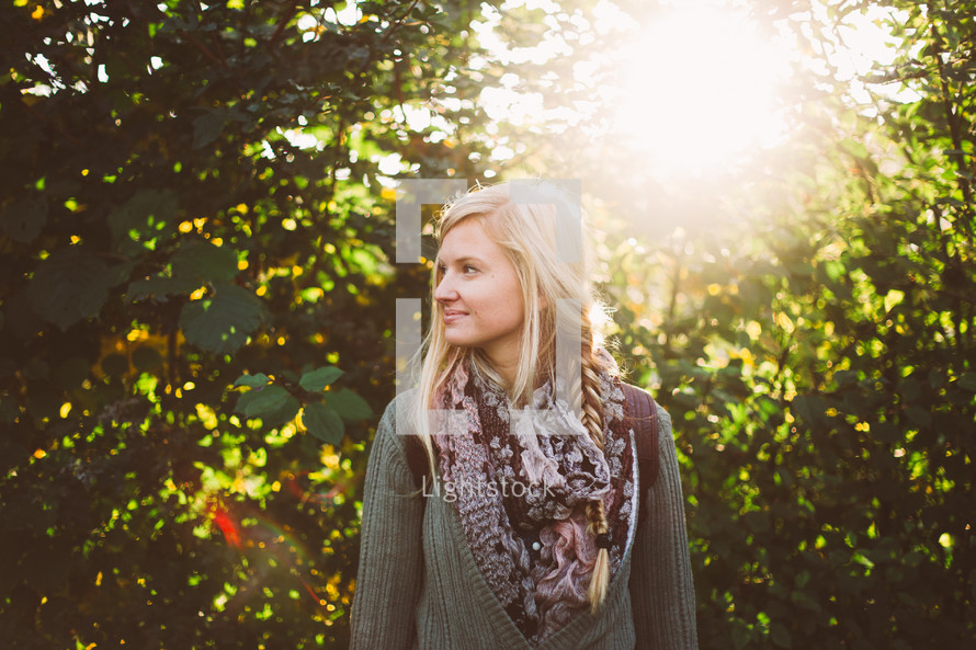 blonde woman standing outdoors and a burst of sunlight 