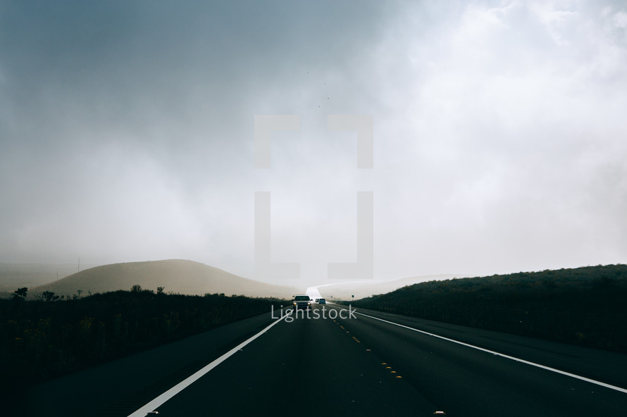a car traveling down a road in the morning 