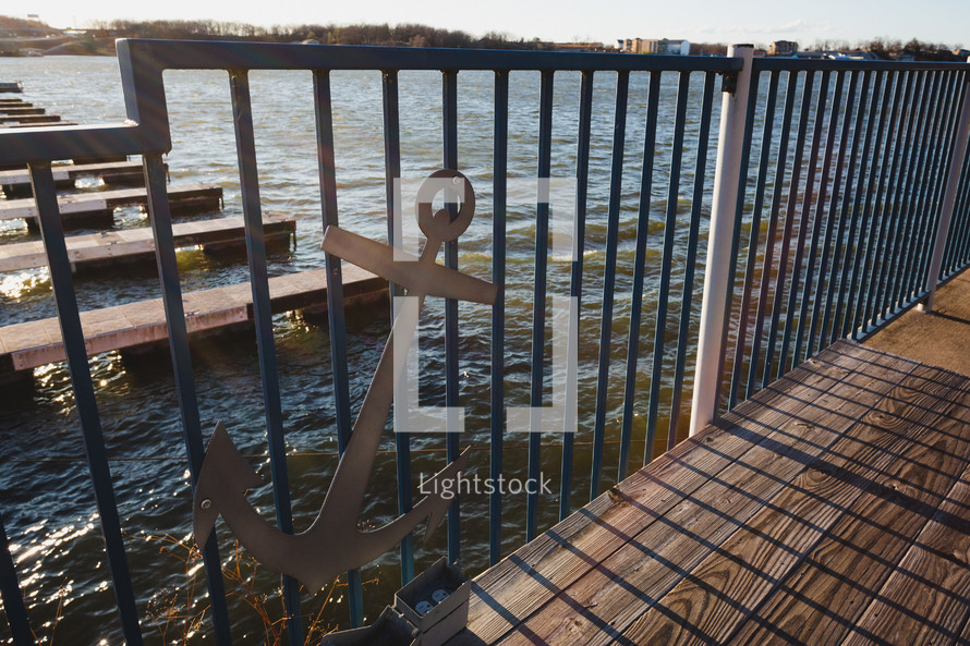 Fence with anchor on it next to water and dock