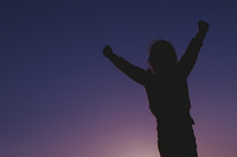 silhouette of a girl child with raised hands 