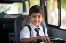 A 7-year-old boy playfully pretending to be a bus driver