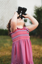 a girl looking through binoculars 