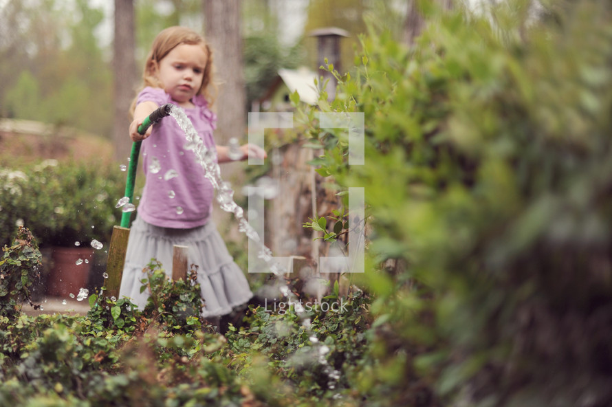 girl child watering a garden 
