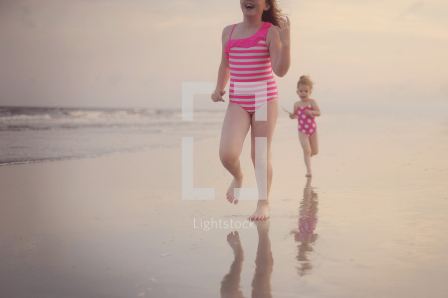 young girls running on a beach 