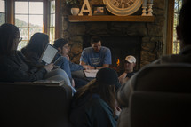 group of young adults sitting on a couch reading scripture 