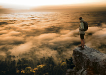 Man climbing a mountain at sunset with scenic view