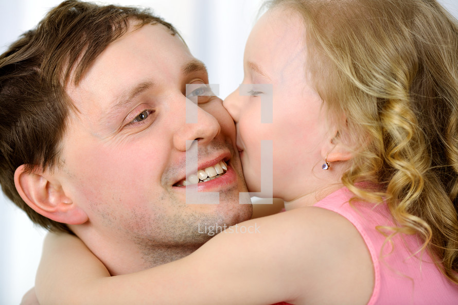 Little girl kissing fathers cheek