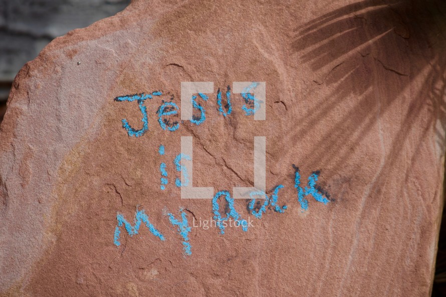 Jesus is my rock written on a rock in sidewalk chalk 