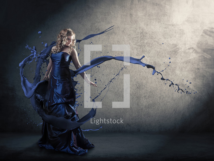 A woman in a blue dress with abstract paint splatters.