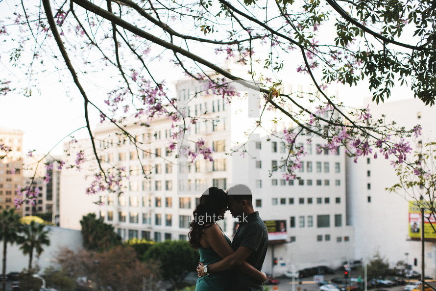 couple hugging and a city in a background