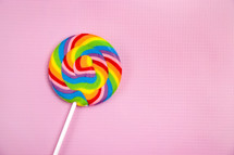 rainbow lollipop on pink background 