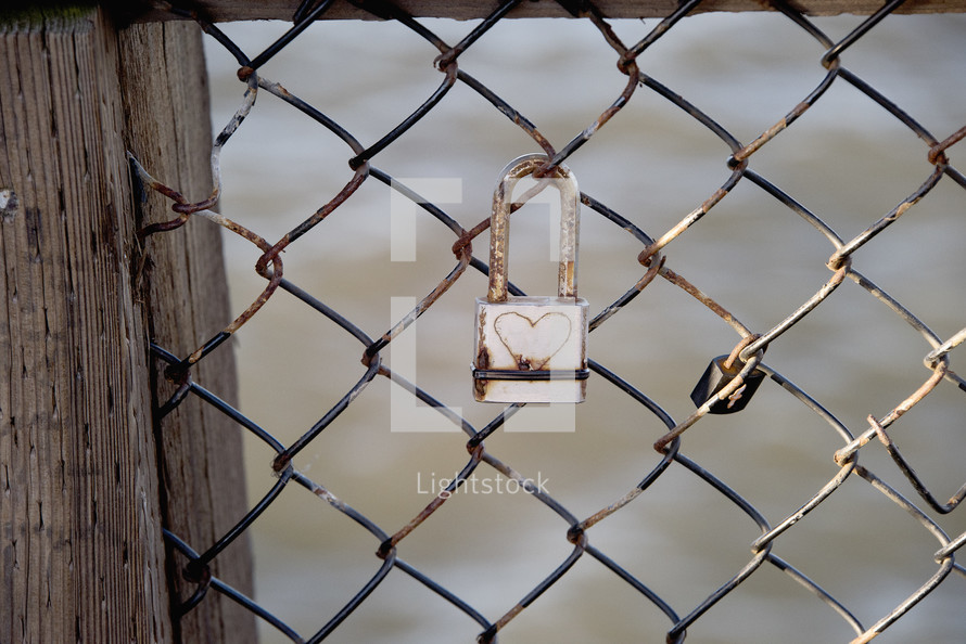 a love lock on a chain link fence 