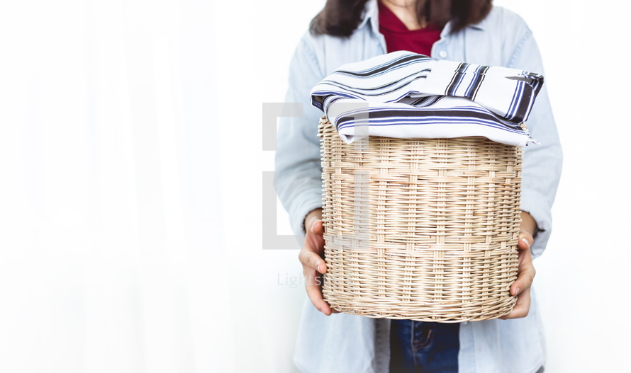 woman holding a basket of clothes 