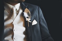 Feather boutonniere on a suit lapel.  