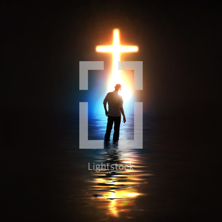 A man standing before a glowing cross.