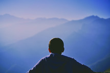 man looking out at a mountain view 