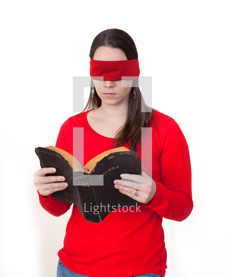 A blindfolded woman reading a Bible. 