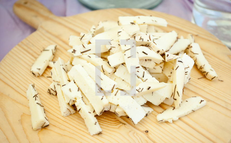White cheese with rosemary on the wooden cutting board