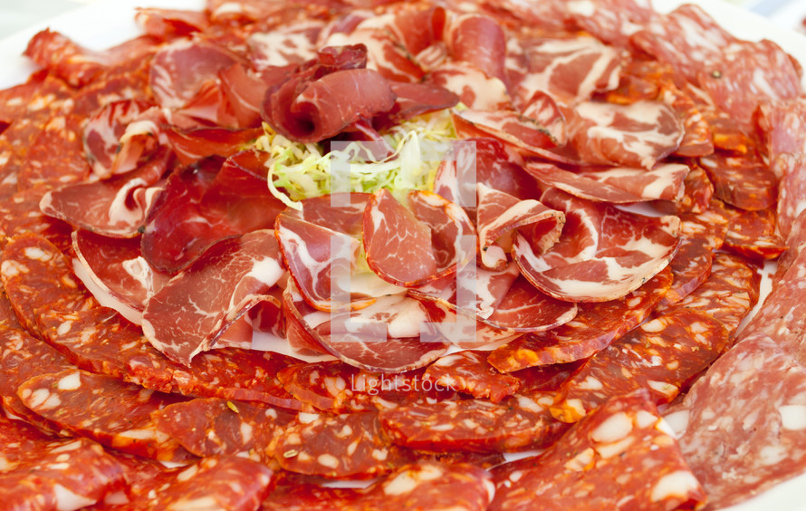 Plate of ham and spicy salami.